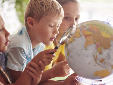 Children using magnifying glass in Geography
